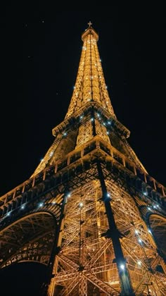 the eiffel tower lit up at night with lights on it's sides