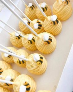 honeybee cupcakes with white and yellow frosting are arranged on a tray