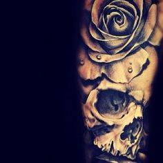 a man's arm with a rose and two skulls on it, all covered in black ink