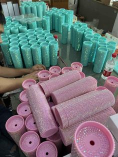 a table topped with lots of pink and blue vases