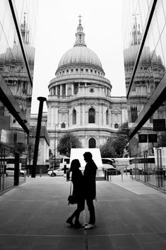 black and white photograph of two people standing in front of the dome of st paul's cathedral