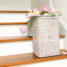 a basket sitting on the steps with flowers in it