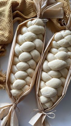 two bags filled with white bread sitting on top of a table