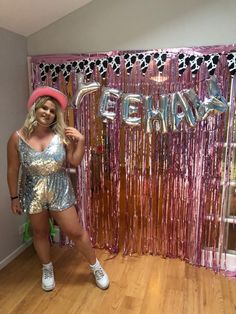 a woman standing in front of a pink and silver backdrop with the word friends on it