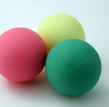 three colored balls sitting next to each other on a white surface