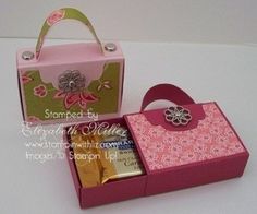 a pink box with some gold bars in it next to a pink and green bag