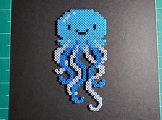 an octopus made out of perler beads sitting on top of a piece of paper