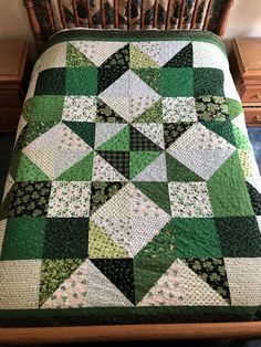 a green and white quilt on top of a bed