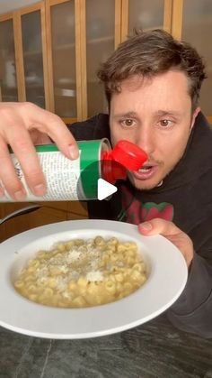 a man is pouring something into a bowl of macaroni and cheese on a plate