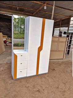 two white and orange dressers sitting in the dirt