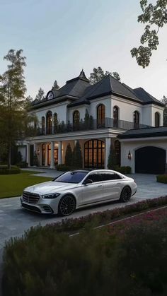 a white car parked in front of a large house