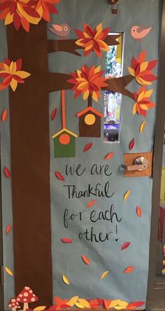 a bulletin board decorated with fall leaves and birds on the tree, saying we are grateful for each other