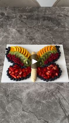 a butterfly made out of fruit on top of a white plate