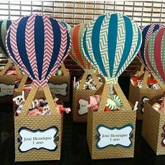 there are many hot air balloons in baskets on the table with name tags attached to them