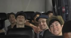 a group of young men riding on the back of a bus next to each other