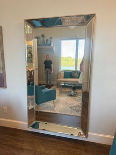 a man standing in front of a large mirror