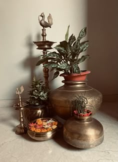 an assortment of potted plants sitting on top of a table next to a candle holder