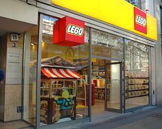 a man walking past a lego store front