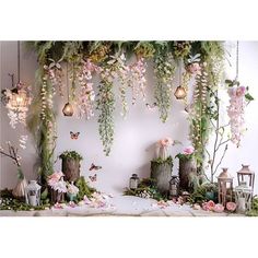 a room filled with lots of fake flowers and greenery hanging from the ceiling above