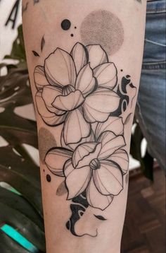 a black and white flower tattoo on the arm