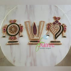 three different designs on a white plate with pink and green stones in the middle,