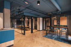 an empty room with wooden floors and blue walls is seen in this image, there are several chairs around the table