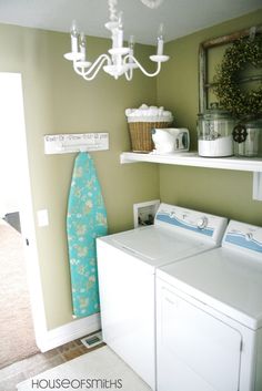 a washer and dryer in a room with a chandelier hanging from the ceiling