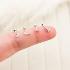 four tiny silver stars are placed on the tip of someone's finger, and they appear to be in different positions