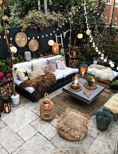 an outdoor living room with lots of plants and decorations