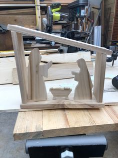 a wooden sculpture sitting on top of a table next to a piece of plywood