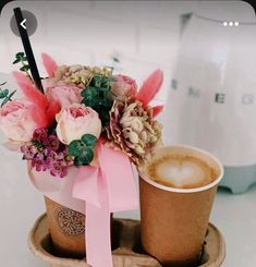 two coffee cups with flowers in them on a tray