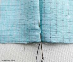 the sewing needle is being used to sew together fabric for a jacket or coat