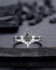 a diamond ring sitting on top of a wooden table next to black and white rocks