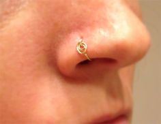 a woman's nose with a gold nose ring on it