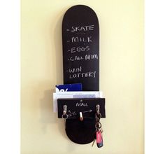 a skateboard mounted to the side of a wall with some keys hanging from it