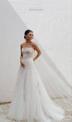 a woman in a wedding dress posing for the camera