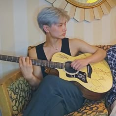 a person sitting on a couch with a guitar