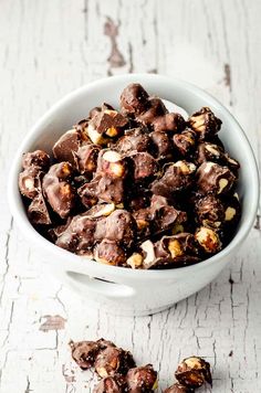 a white bowl filled with chocolate and nuts