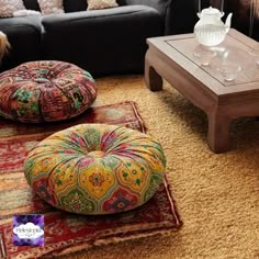 a living room filled with lots of furniture and pillows on top of carpeted flooring