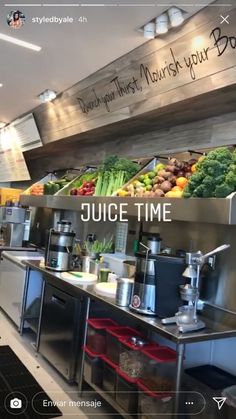 an image of the inside of a restaurant with juice time written on the wall and fresh fruits and vegetables lined up at the counter