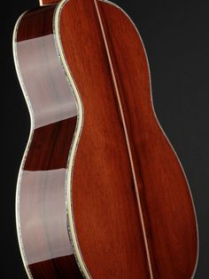 the back and sides of an acoustic guitar with wood grained body, showing the fret