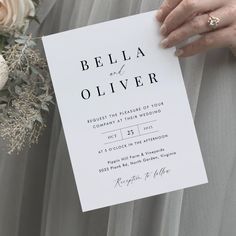 a person holding a piece of paper with the words bella and oliver written on it