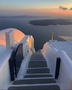 stairs leading up to the top of a building with water and sky in the background