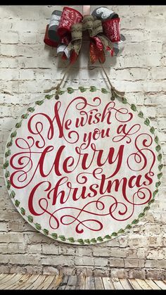 a christmas sign hanging on the side of a brick wall