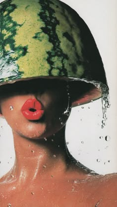 a woman wearing a watermelon helmet and sticking her tongue out to the side