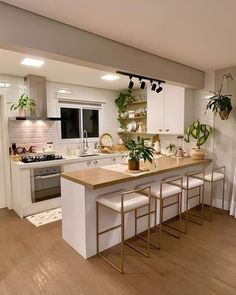 a kitchen with white cabinets and wooden counter tops next to a stove top oven in a home