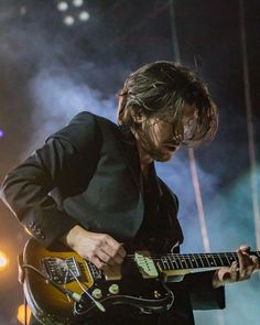 a man playing an electric guitar on stage