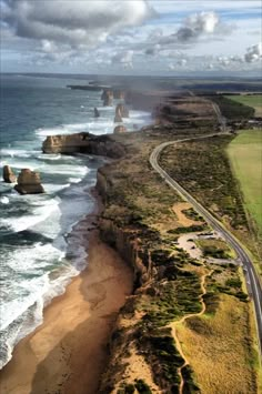 an aerial view of the ocean and coastline with cars driving on it's side