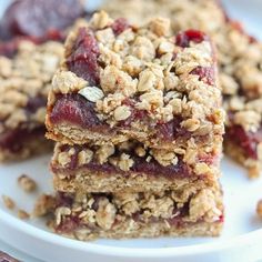 three pieces of fruit and oatmeal bars on a white plate with cherries