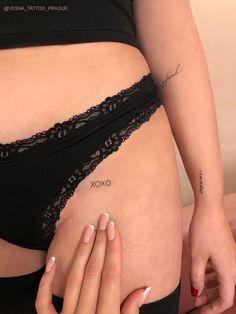 a woman with white nails and tattoos on her stomach